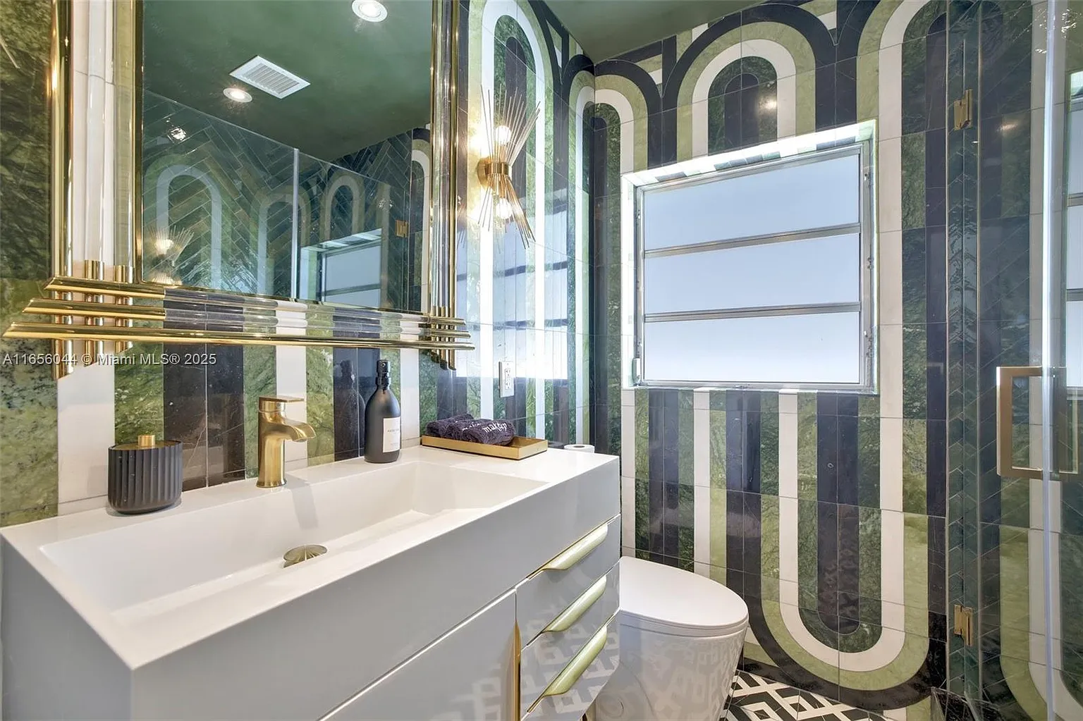 Art deco bathroom with green marble and gold fixtures